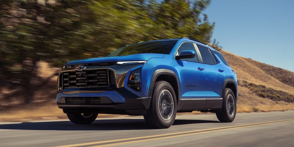A blue Chevrolet Equinox SUV driving down a rural road